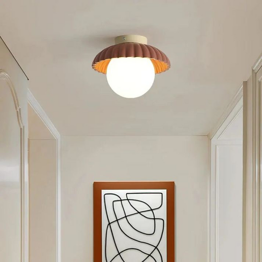 Ceiling lamp with a frosted shade providing warm lighting in the hallway